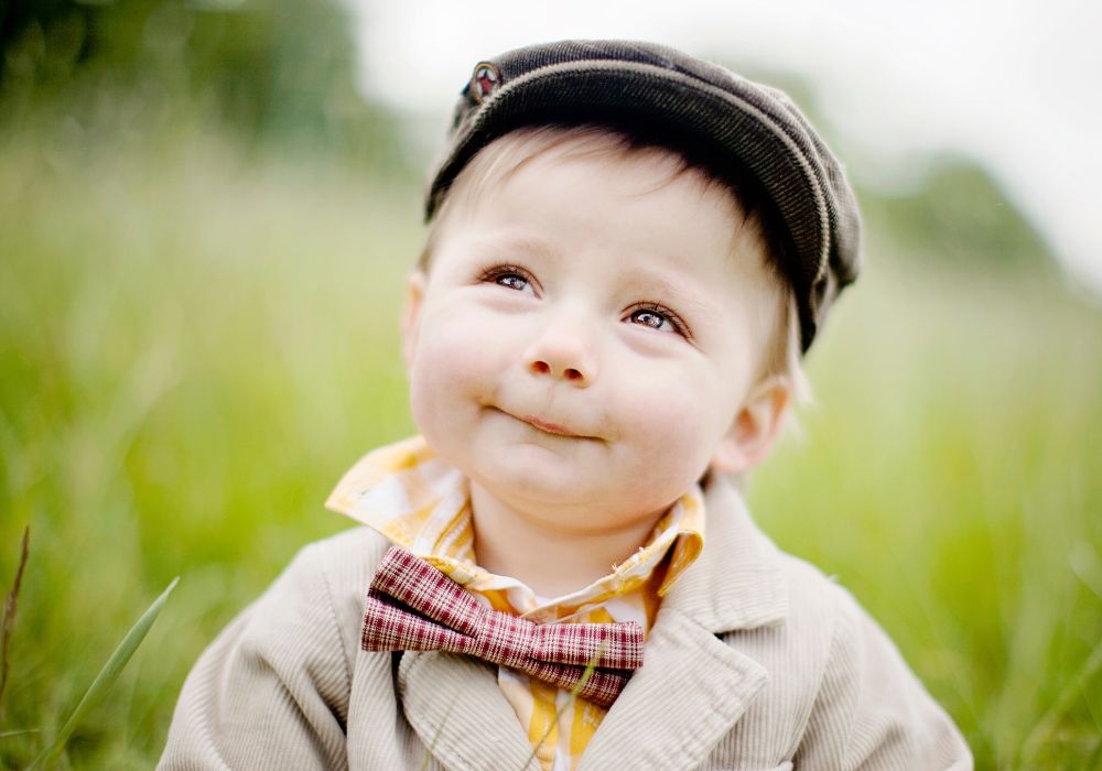 Young boy with a cap on looking into the distance