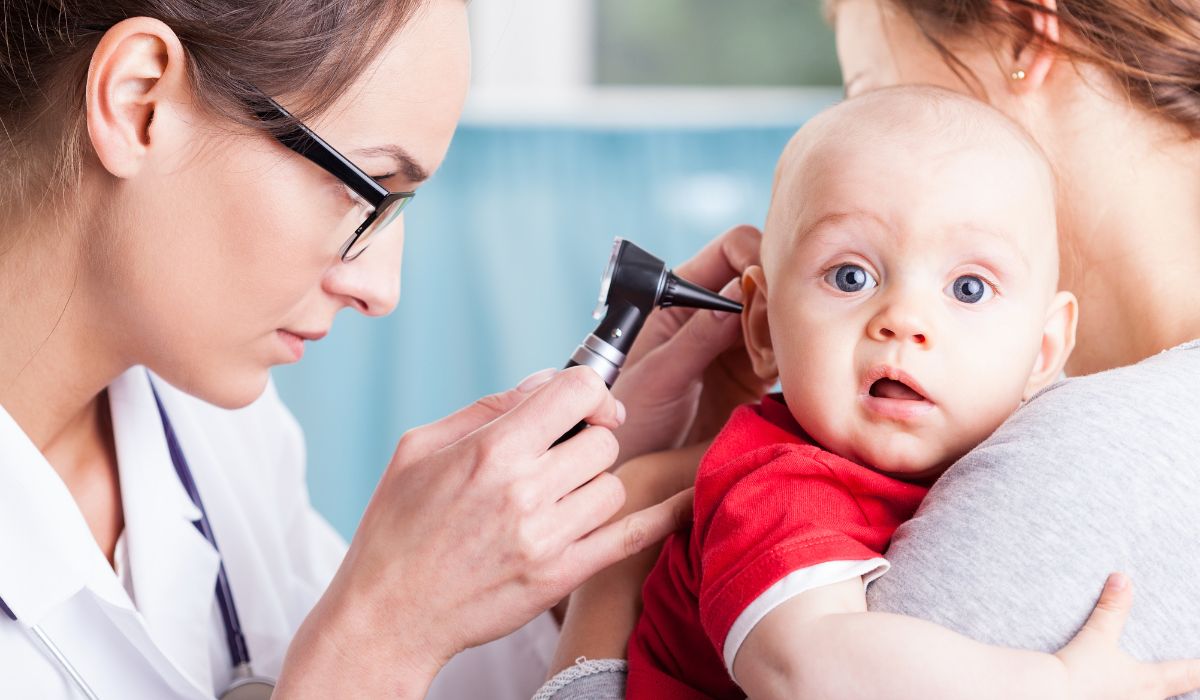 Doctor looking in baby's ear