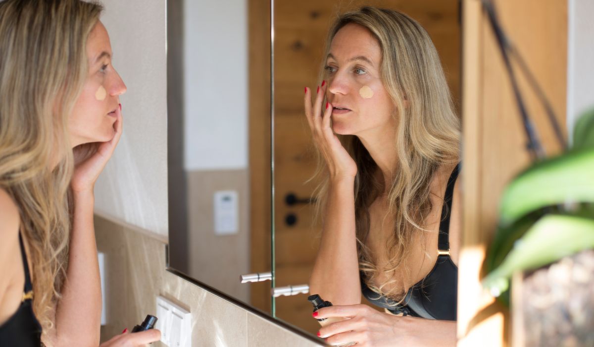 Woman applying foundation to her skin