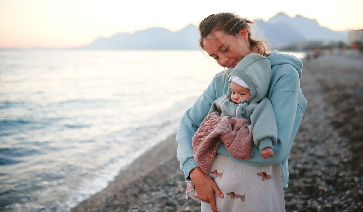Mother with her baby at the beach in cold weather