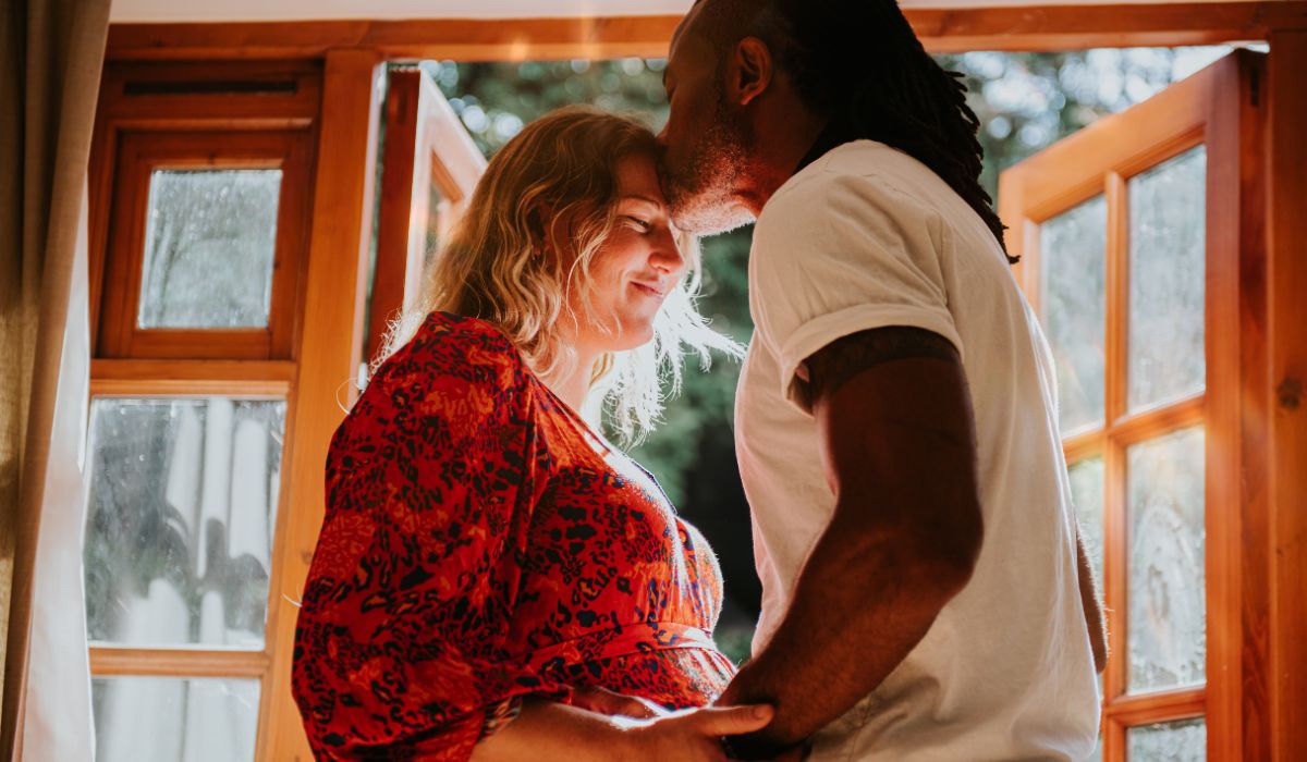 Pregnant woman and man kissing
