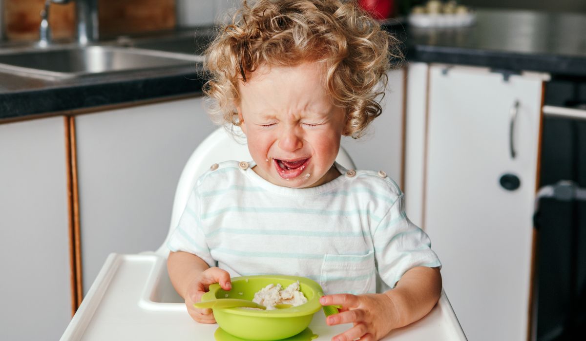 girl crying at her high chair over food