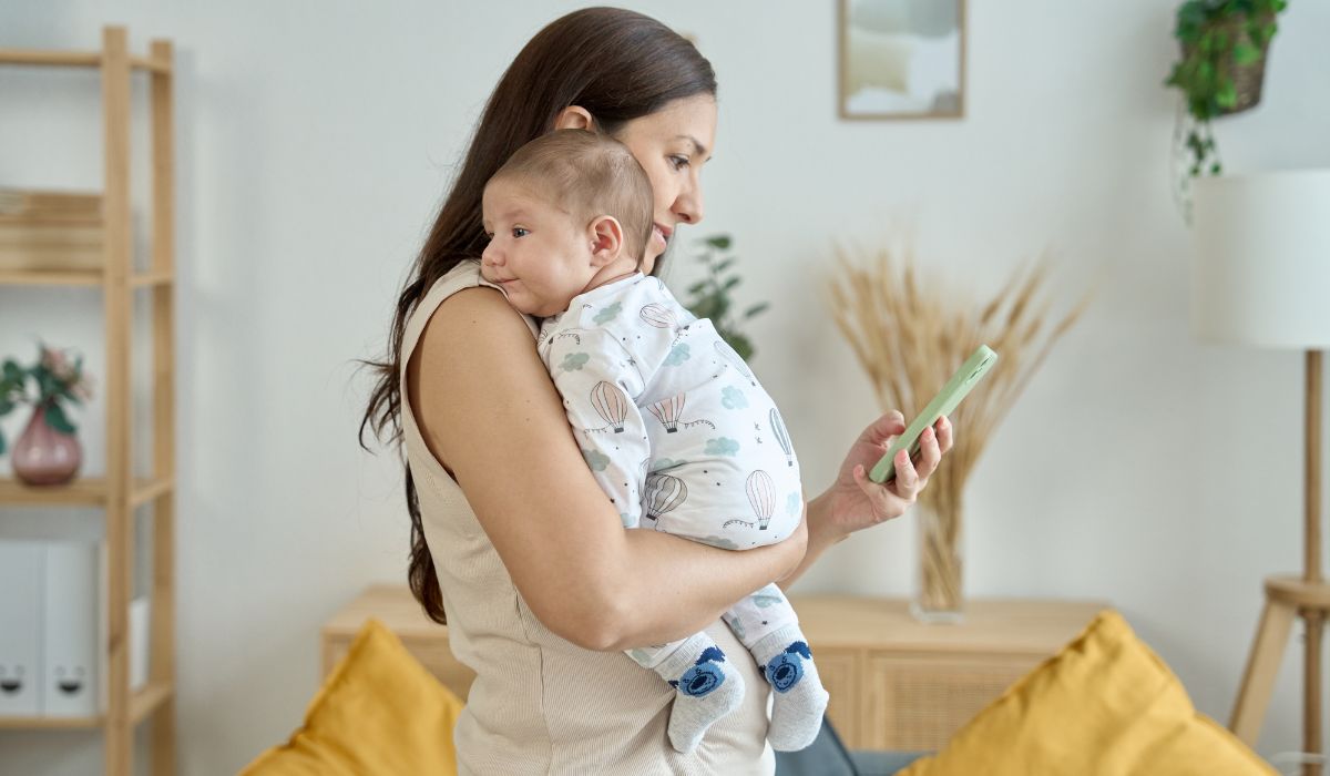 Mother on her phone holding her baby