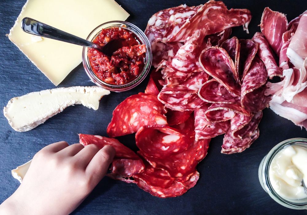 Woman taking a slice of salami