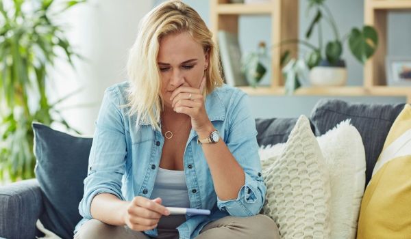 Worried woman looking at a pregnancy test