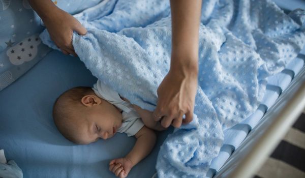 Baby boy asleep in a cot