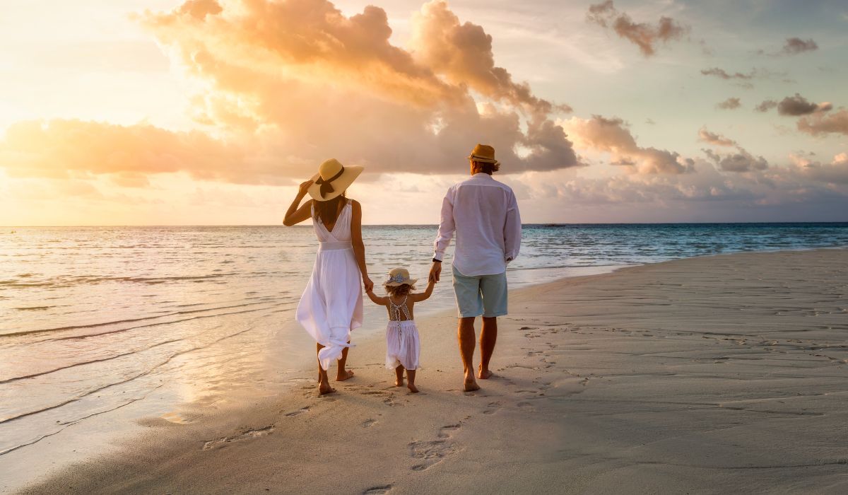 Family on holiday walking on beach
