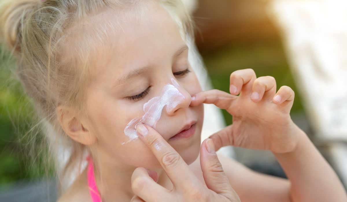 Child applying sunscreen