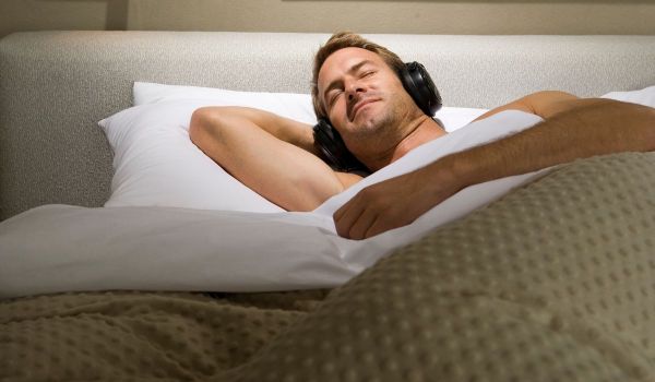 Man asleep wearing noise-cancelling headphones