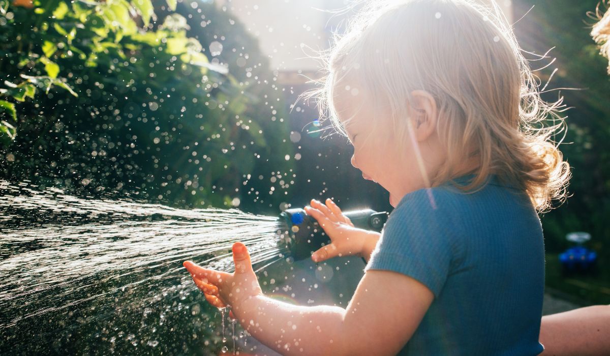 Baby playing with hose
