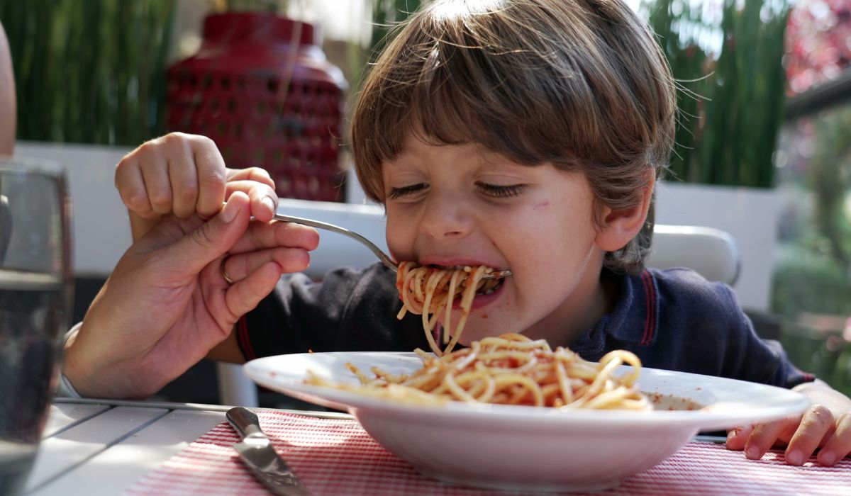 Little boy eating spaghetti