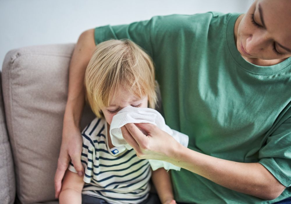 Mother helping child blow nose