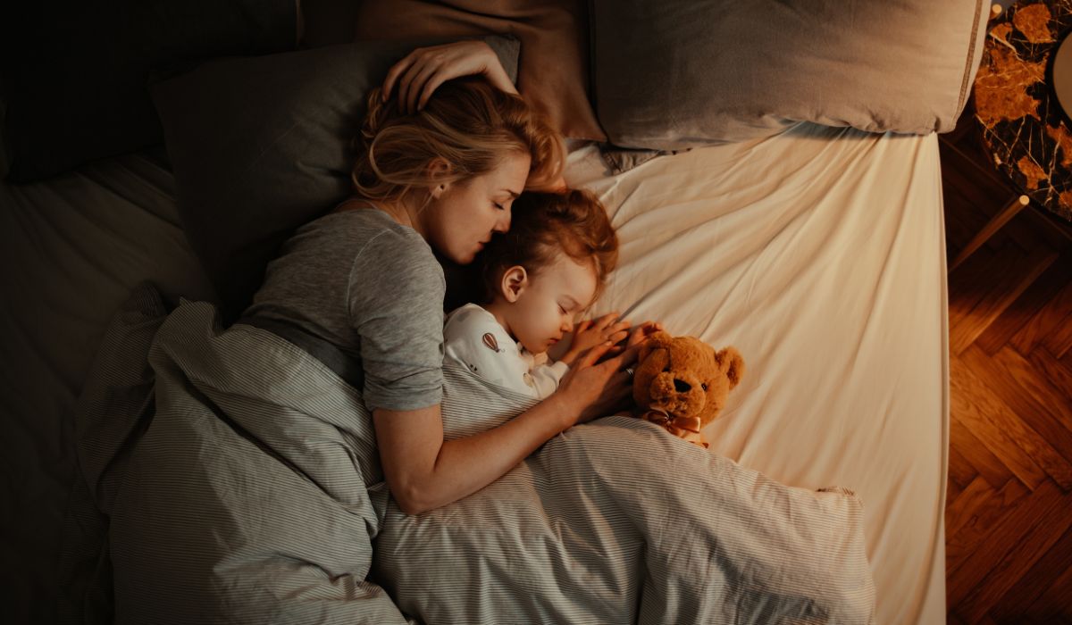Mother sleeping with toddler in bed
