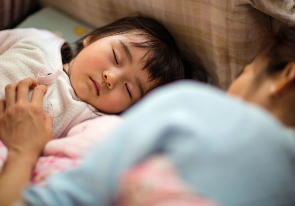 Mother sleeping with toddler