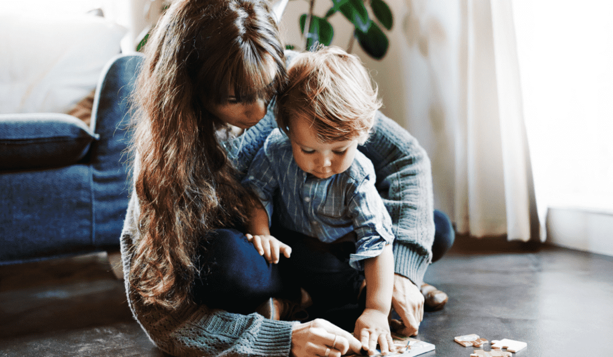 Young mum playing with toddler on the floor