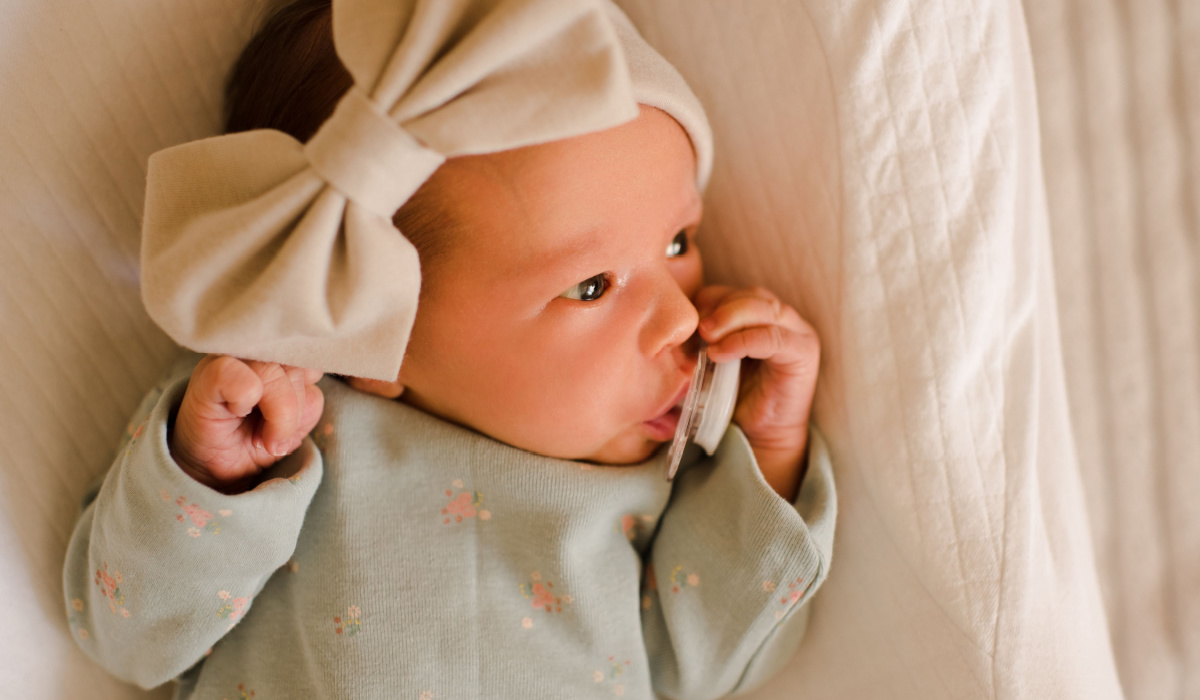 Newborn baby girl wearing hair band with bow