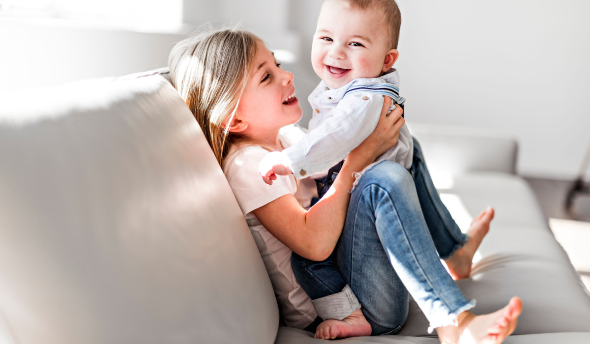 Toddler girl holding her baby sister
