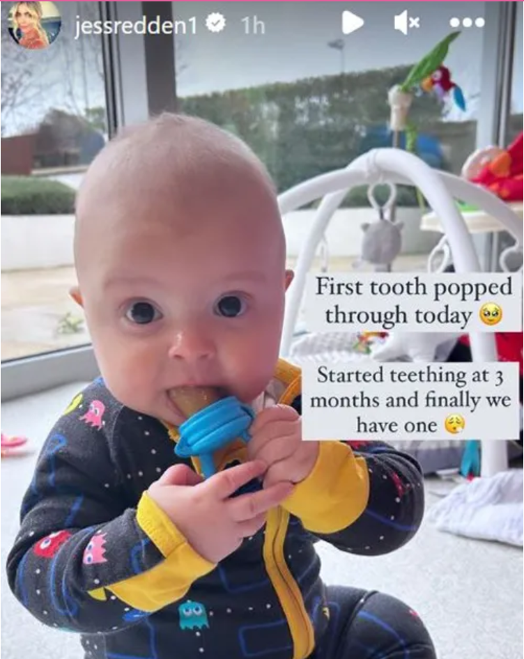 Jess Redden's son Bobby sitting on the floor with a teething toy