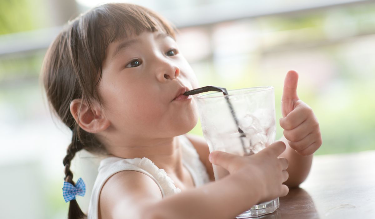 Little girl drinking glass of ice water