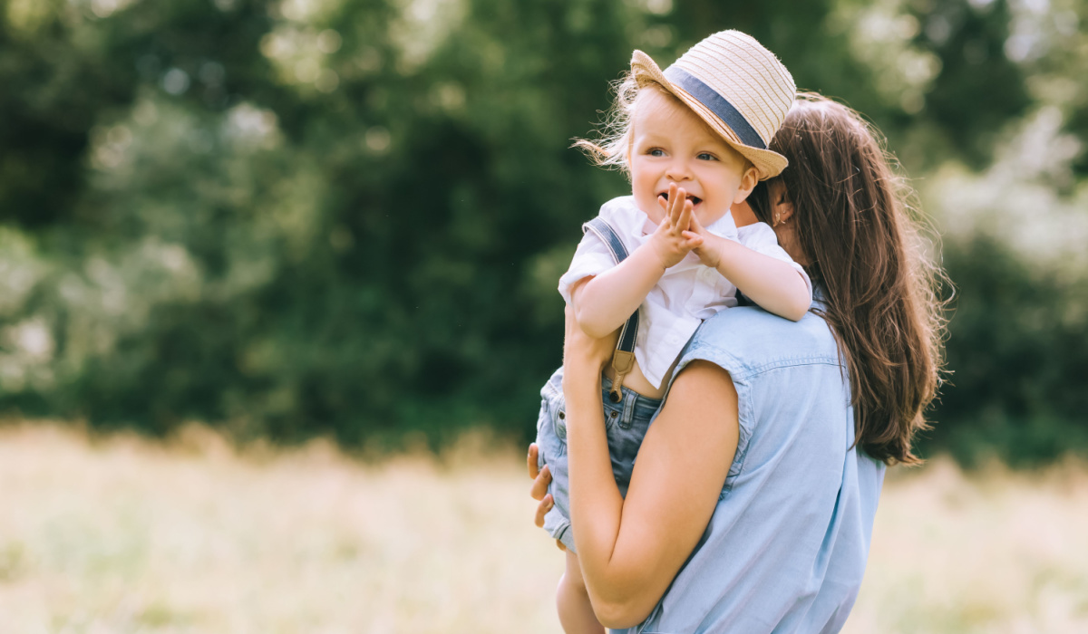 Mother holding toddler son outside