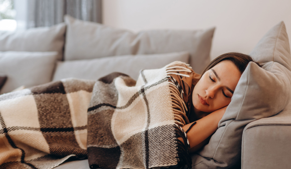 woman napping under blanket on the sofa
