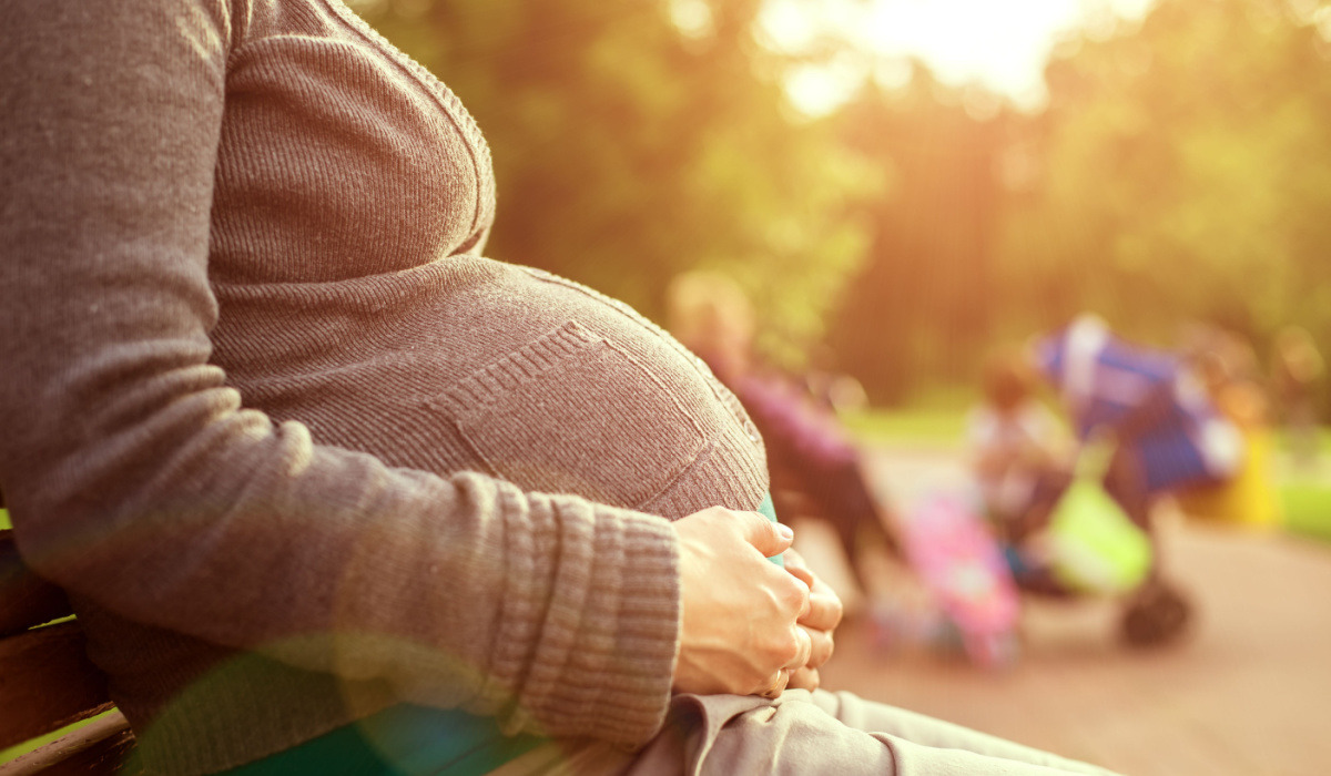 Pregnant woman sitting on park bench
