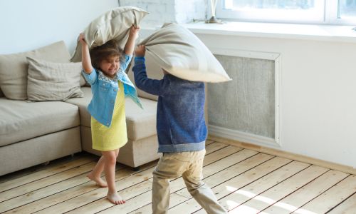Two children pillow fighting