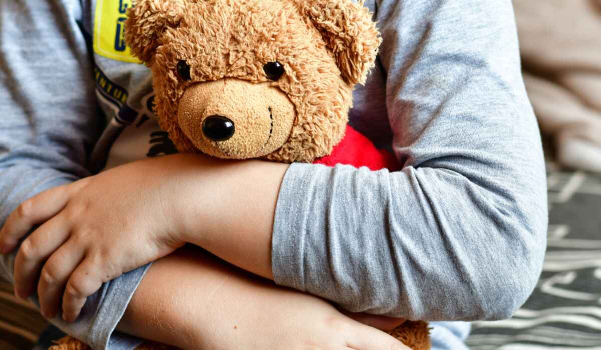 Little boy hugging teddy bear