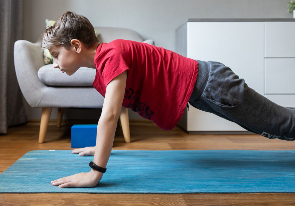 Boy doing push ups at home on mat