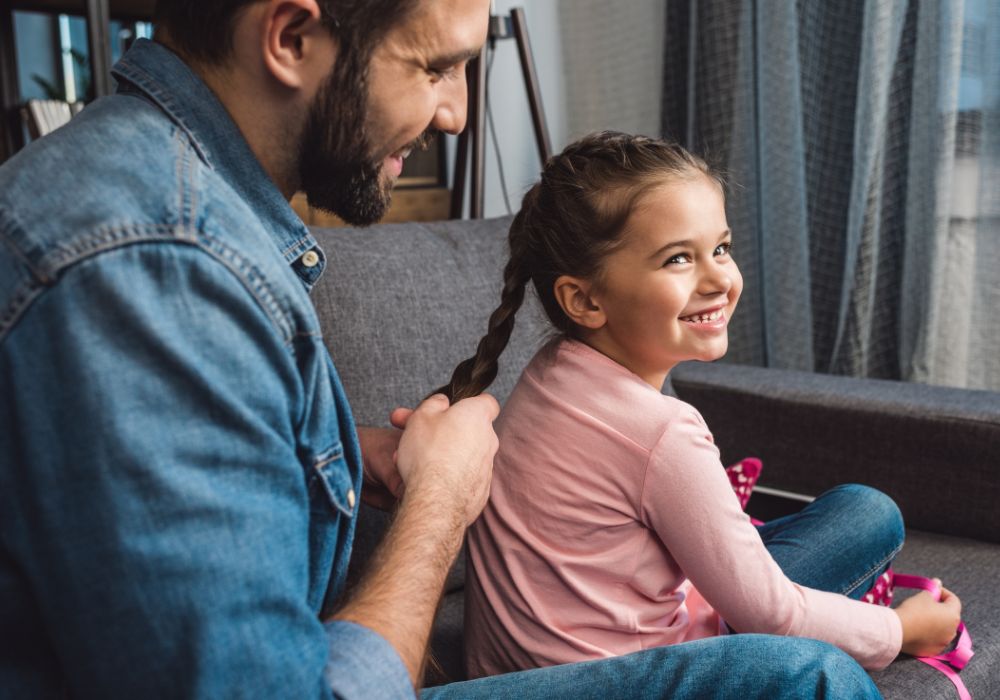 Dad braiding daughter's hair