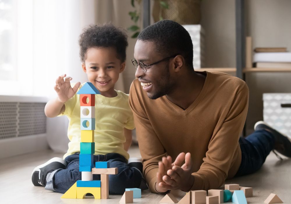 Dad playing blocks with son on the floor