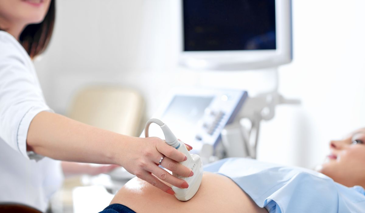 Doctor performing ultrasound on pregnant woman