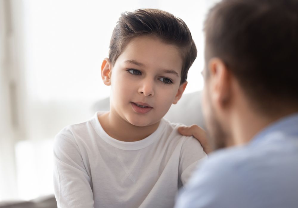 Father talking to son and putting hand on shoulder