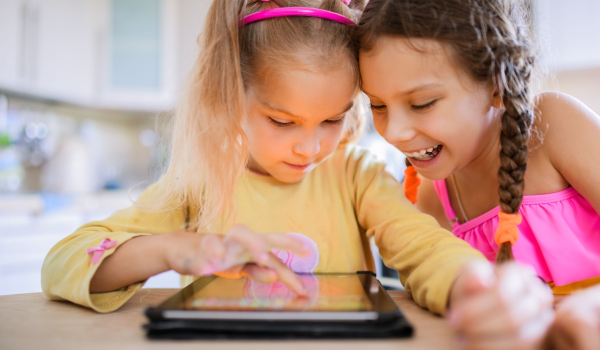 Two kids looking at an iPad