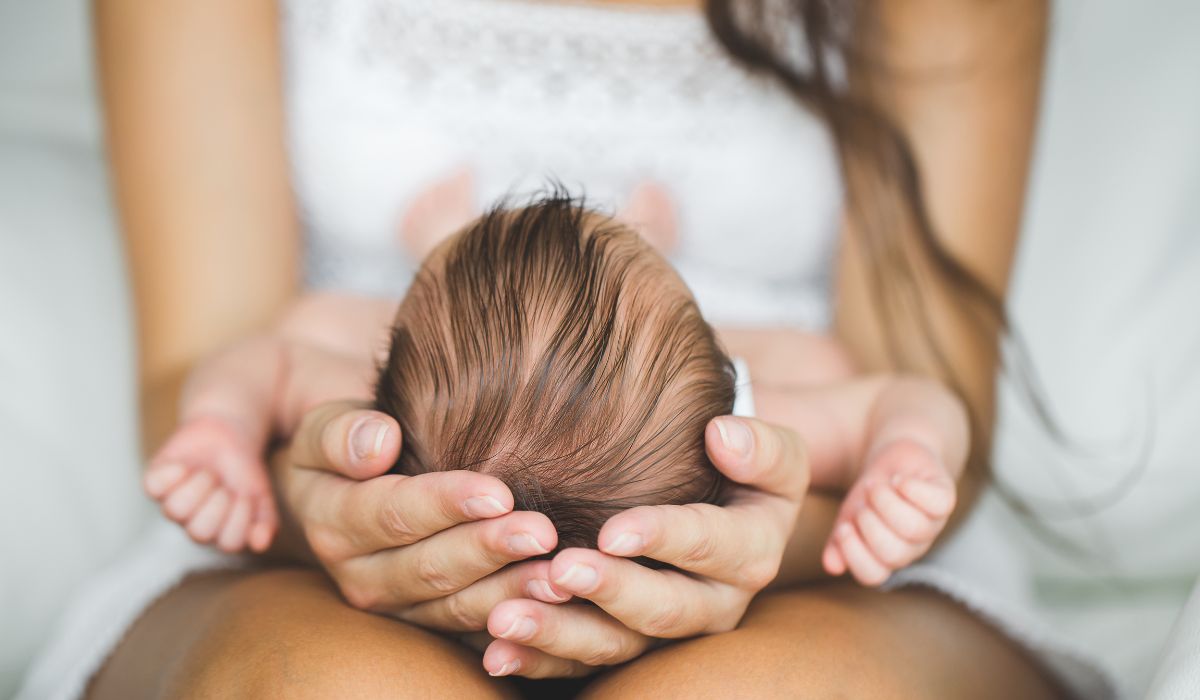 Woman and newborn baby on knee