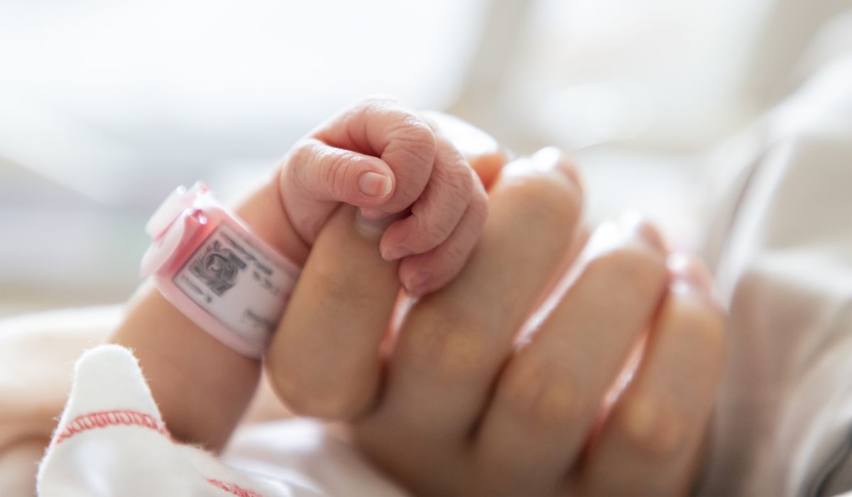 Baby holding mother's thumb