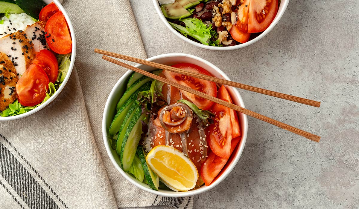 Beautiful composition with poke bowls on gray background with napkin close up