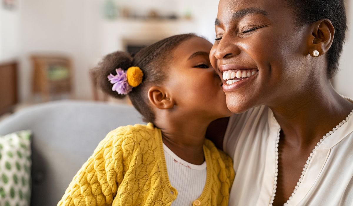 Little girl kissing mother on cheek