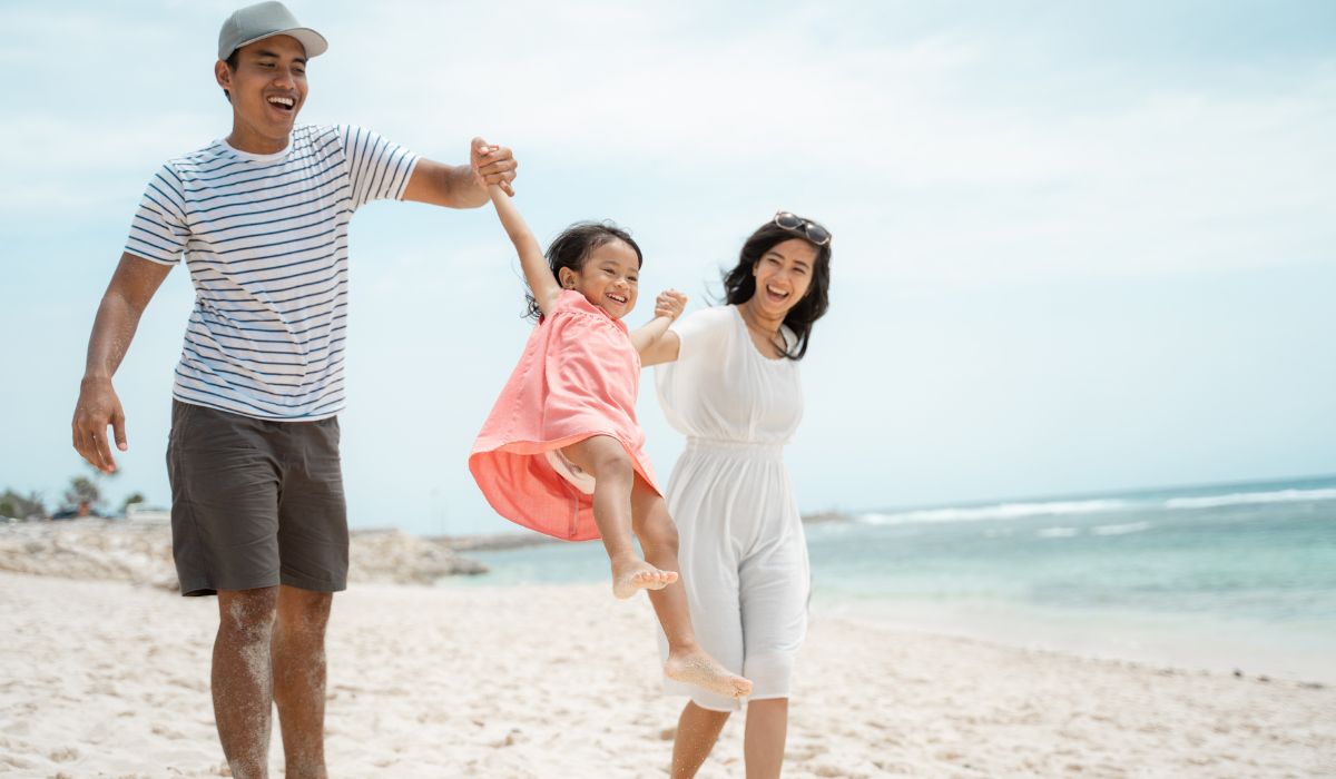 Parents swinging daughter by arms