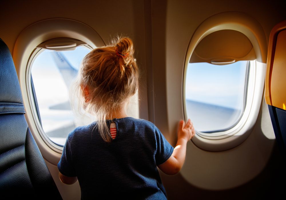 Girl looking out a plane window