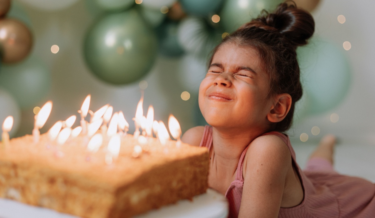 Little girl blowing out birthday candles.