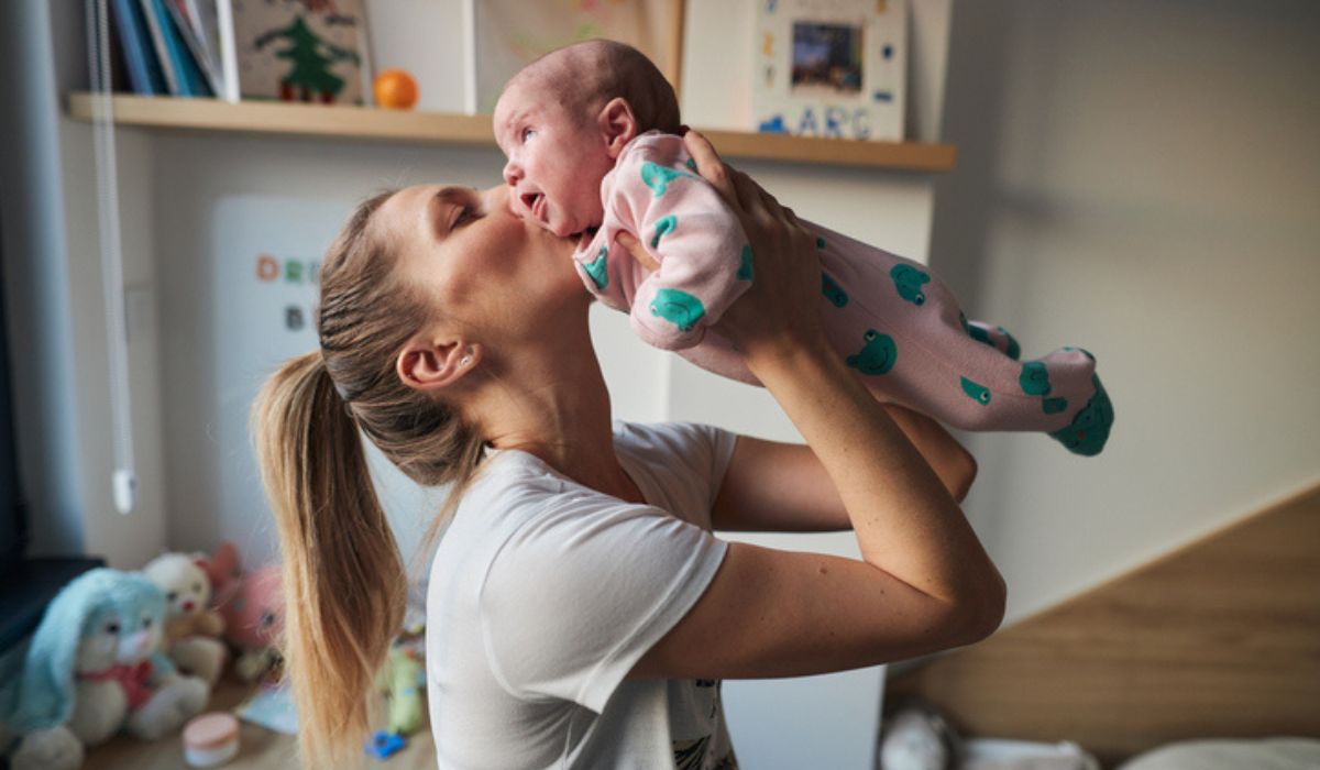 Mum kissing newborn baby.