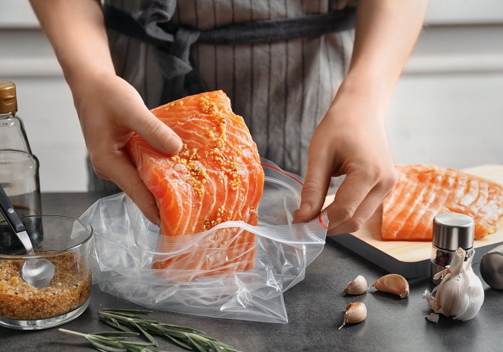 A person in a kitchen cooking salmon
