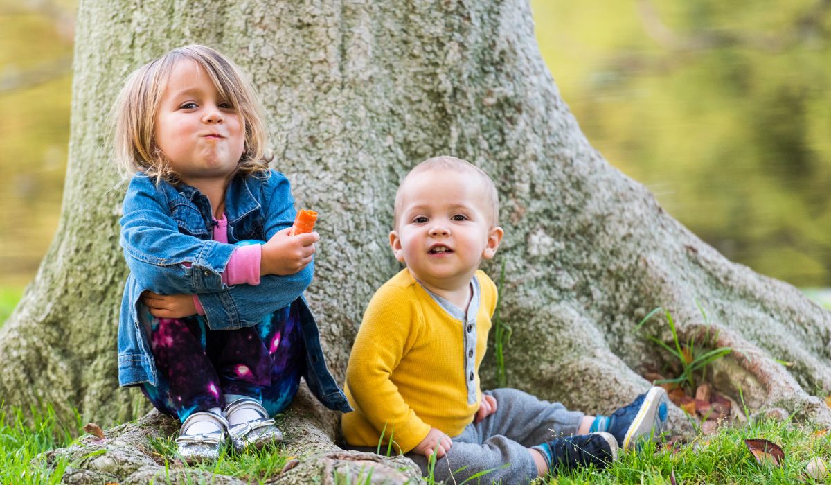 Two toddlers under a tree