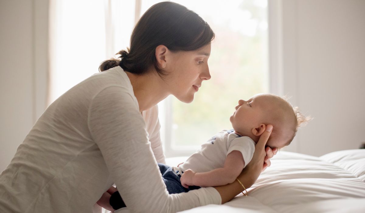 Mother holding baby in bed