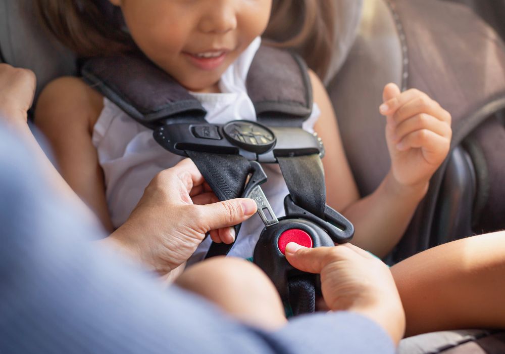 Parent buckling child into car seat