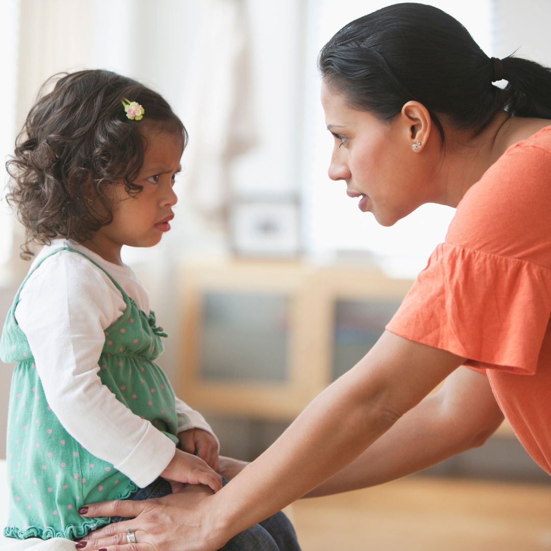 Mother talking to grumpy toddler