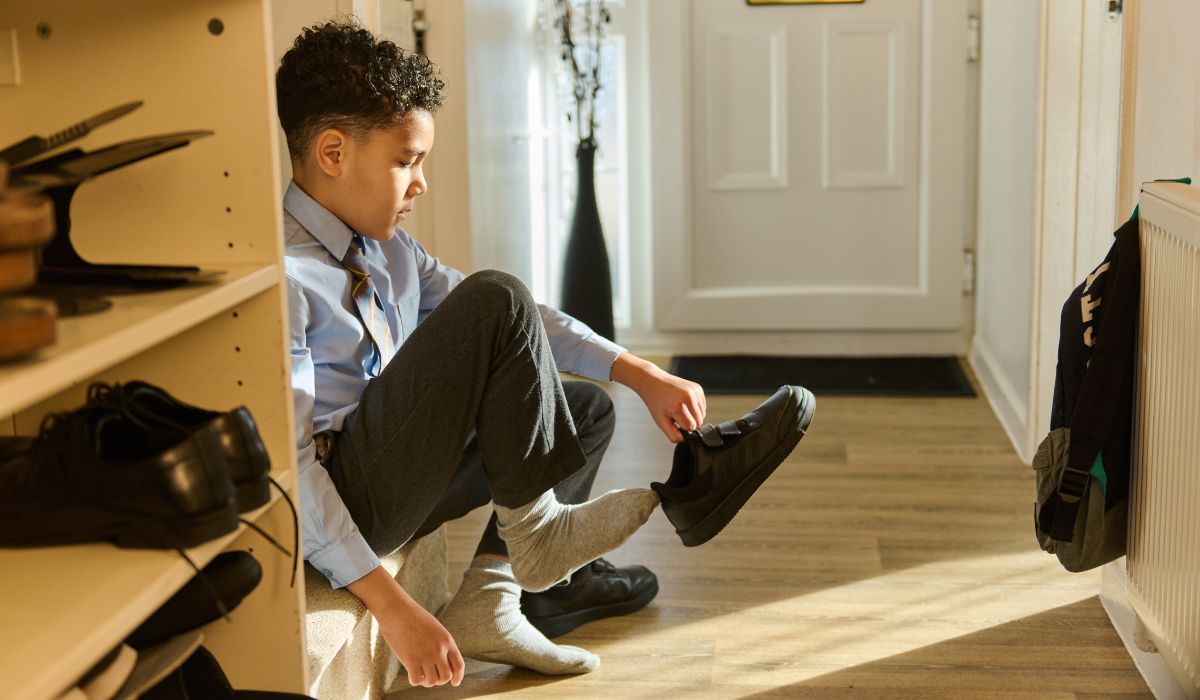 Boy putting on school shoes