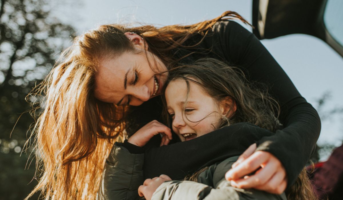 Mother with arms around daughter