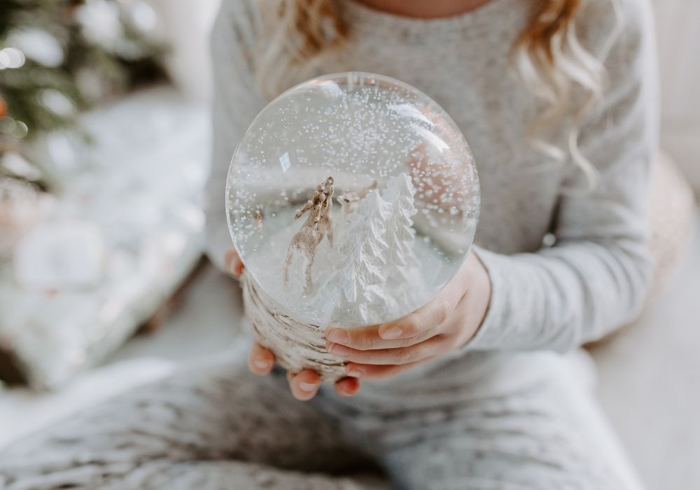 Close up of little girl holding snow globe